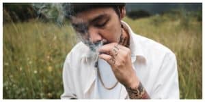 Side view of man smoking marijuana joint