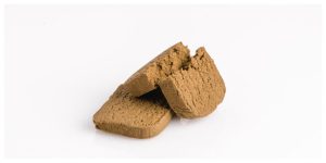two pieces of golden hashish on white background