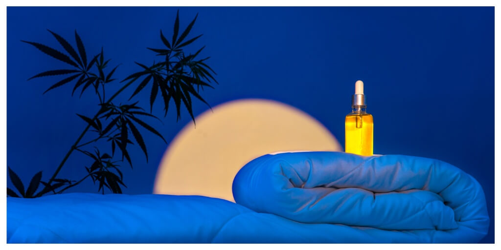 Bottle of CBD oil and marijuana branch on a blanket podium in beam of moon like light and blue background light
