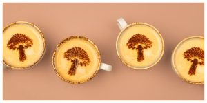 shot from above of 4 cups of mushroom coffee with foam and mushroom latte art
