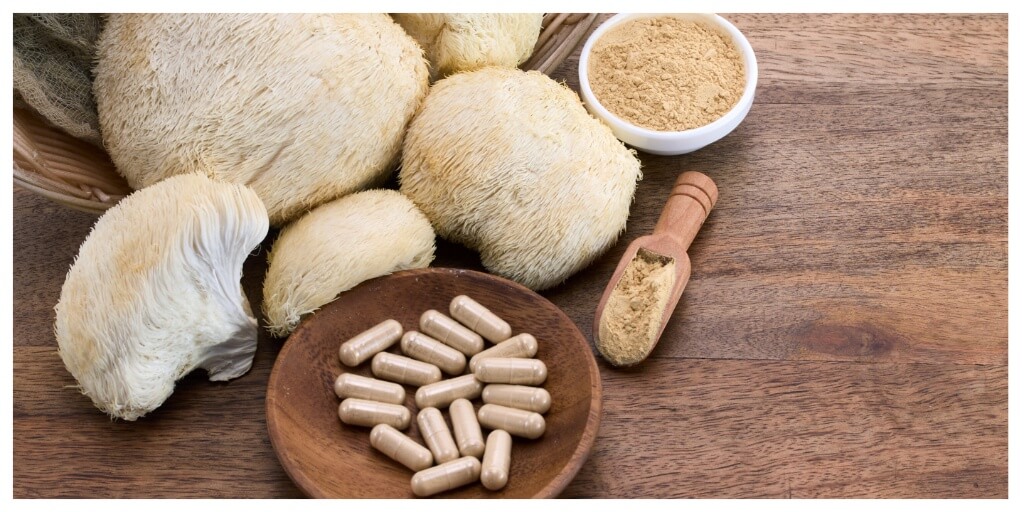Lion’s Mane mushroom and supplement capsules on a wooden table — best lion's mane supplements for focus and natural brain health support