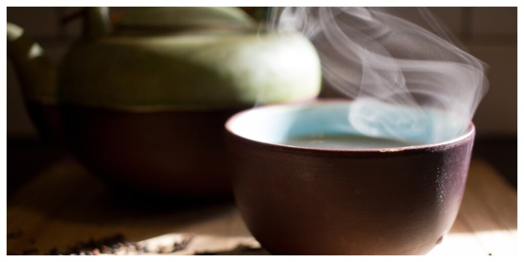a steaming cup of hot smoking tea in the sunlight