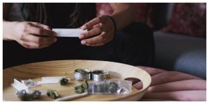 woman sitting on a couch with the perfect cannabis accessories rolling setup